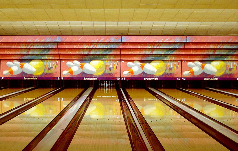 A frontal shot of the bowling lanes of La Florida can be 
                            appreciated. At the back, in lane 10 you can see the 
                            pines perfectly arranged. Also you can see an artistic 
                            mural with four paintings of three pines and a ball in 
                            each lane.