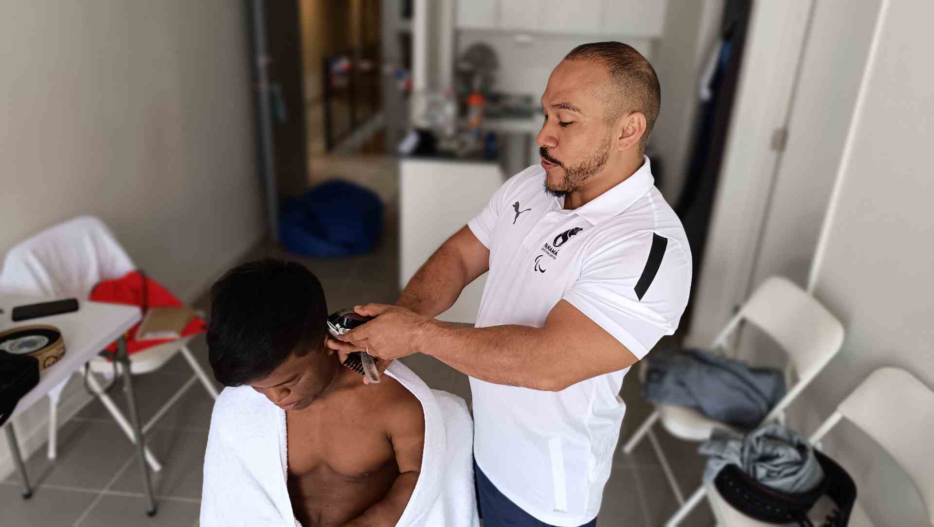Para pesista panameño se sacó la malla para trabajar como barbero en la Villa Parapanamericana